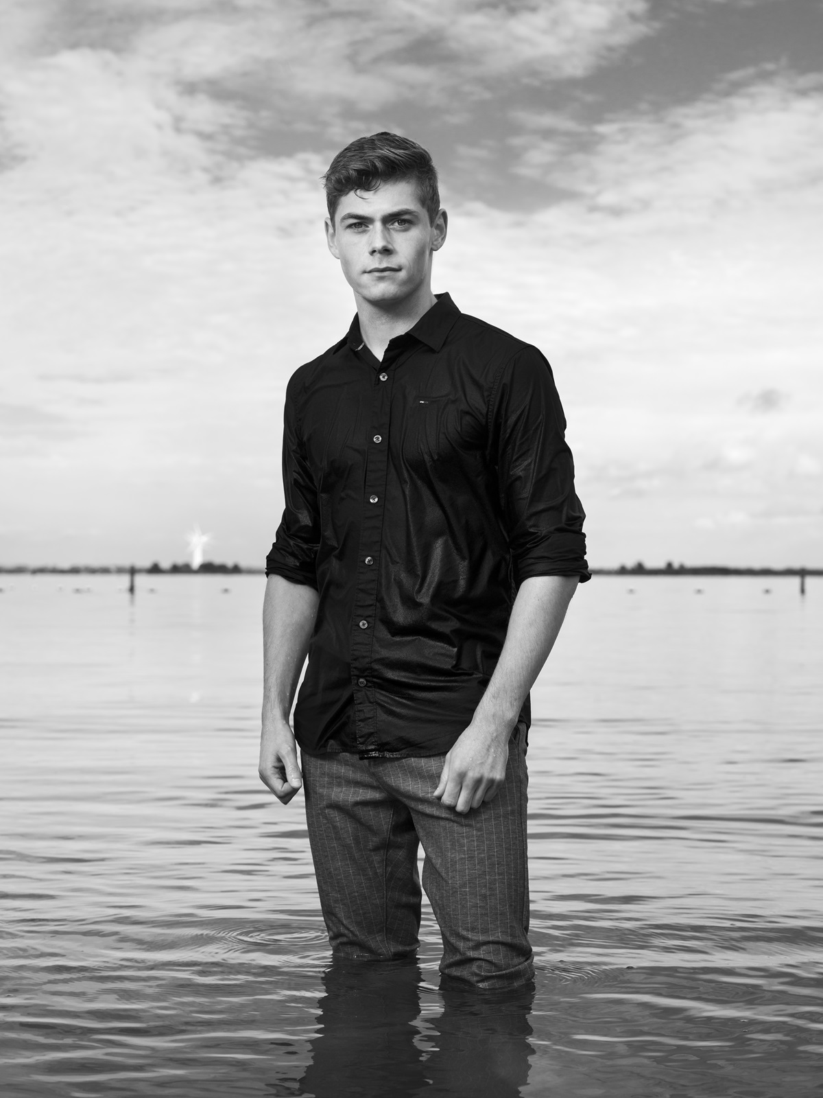 Foto van jongen tot zijn knieën in het water, door fotografe Robin de Puy.
